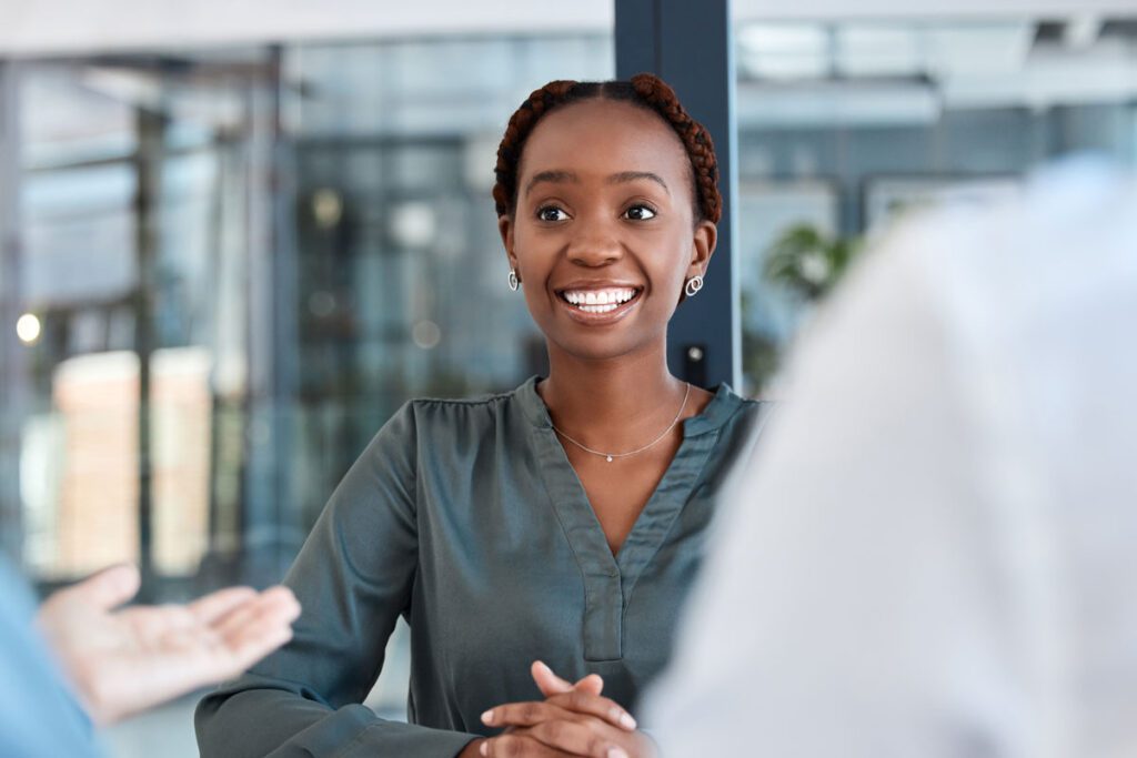 A rural healthcare consultant sits at a desk while talking to her colleagues - Stroudwater