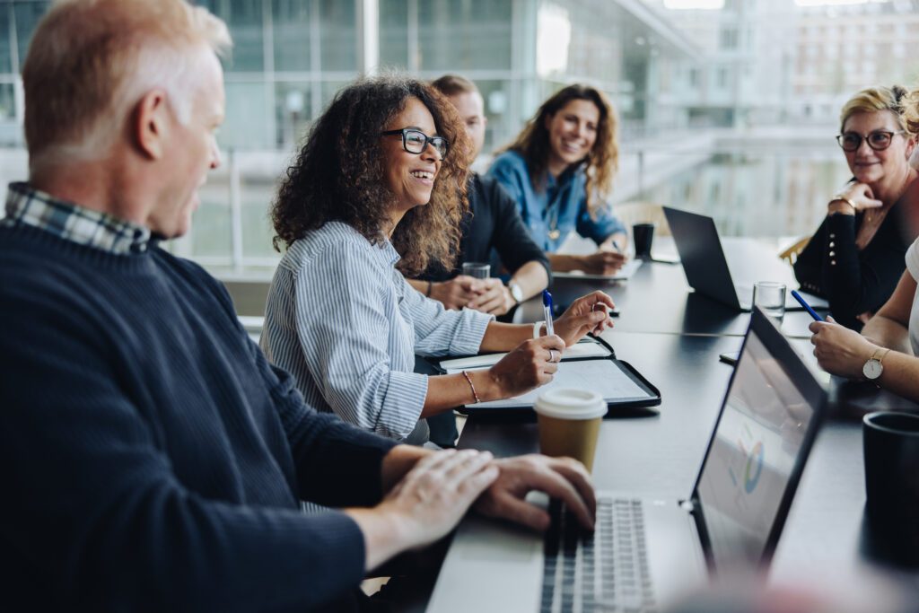 Five healthcare professionals smiling during a meeting